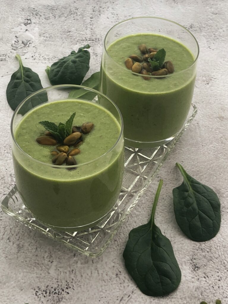 2 gläser gefüllt mit grünem smoothie aus banane und spinat